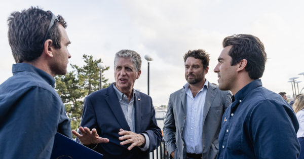 From left to right, Charlie Enright, skipper of 11th Hour Racing Team, middle left, Rhode Island Governor Daniel McKee, middle right, Jeremy Pochman, CEO & co-founder of 11th Hour Racing, and right, Mark Towill, CEO of 11th Hour Racing Team.